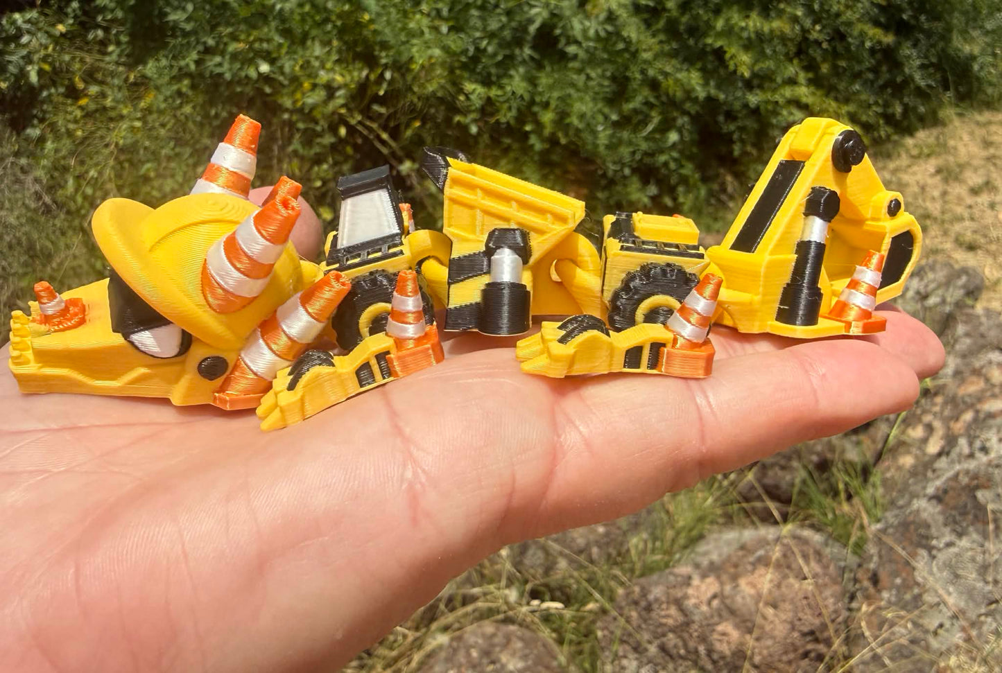 3D printed excavator mini dragon with traffic cones on a hand held flat