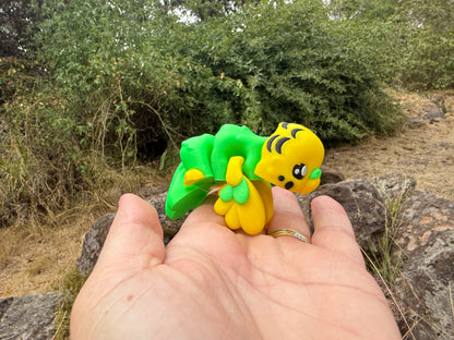 3d printed budgie held in a hand with a natural background