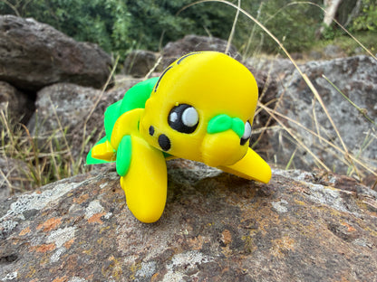 Yellow 3d printed budgie with green bits on a rock