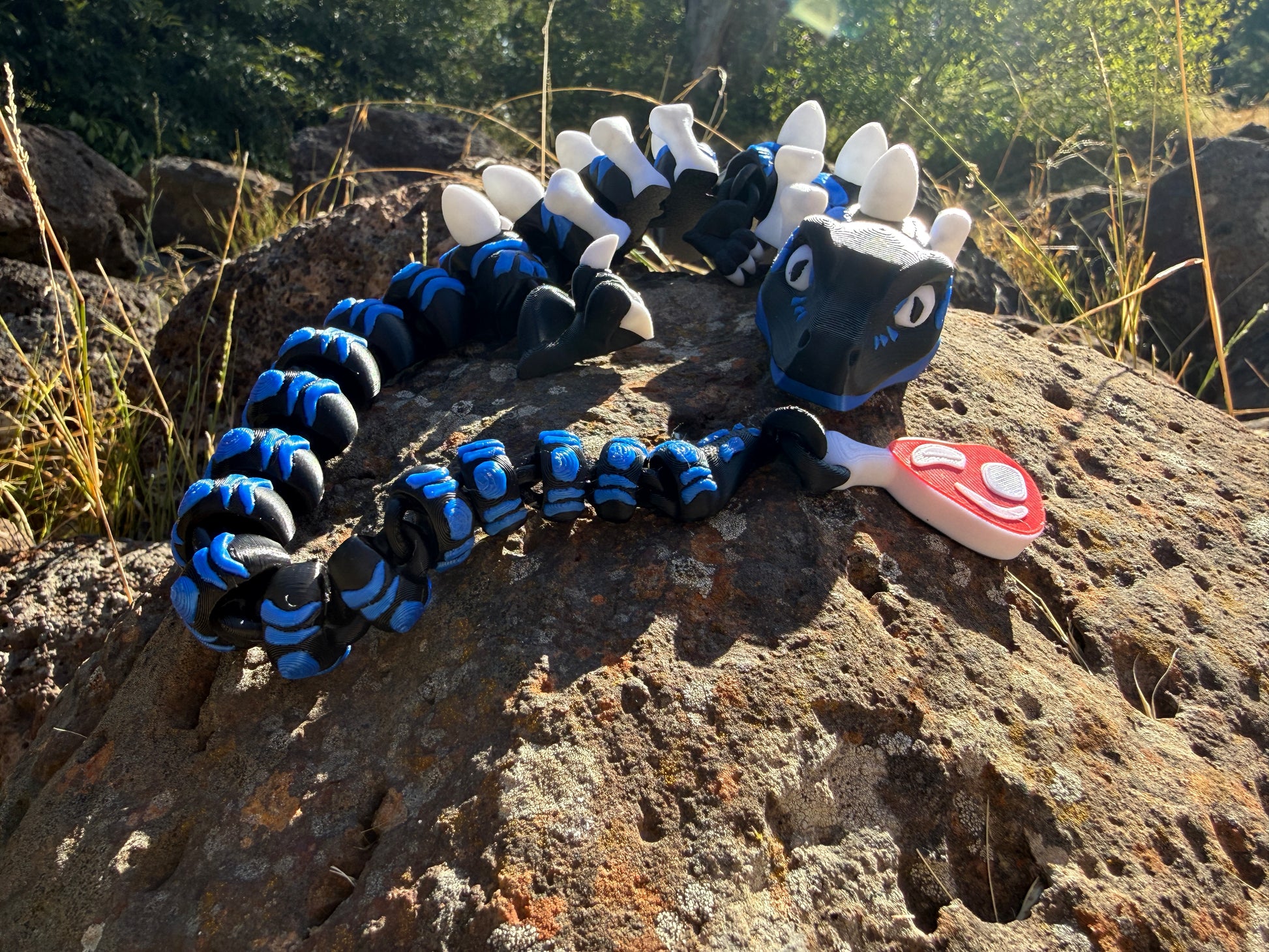 3D printed raptor black and blue. with steak detail tail. bone and egg details down their back