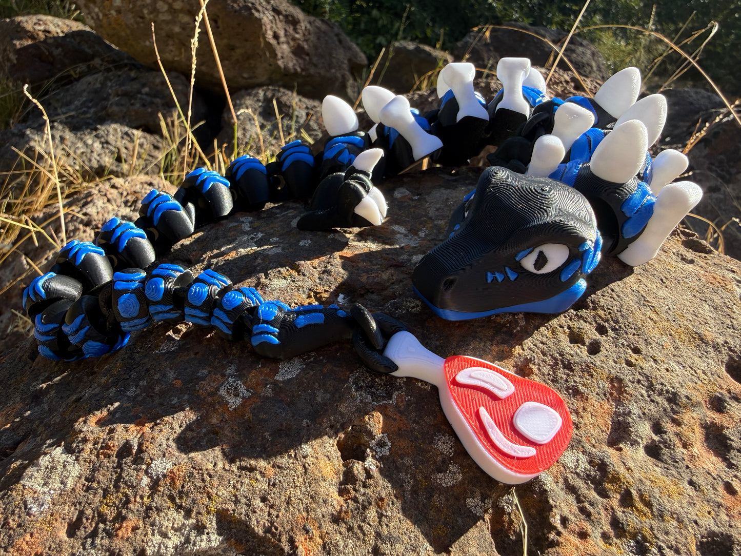 3D printed raptor black and blue. l with steak detail tail. bone and egg details down their back