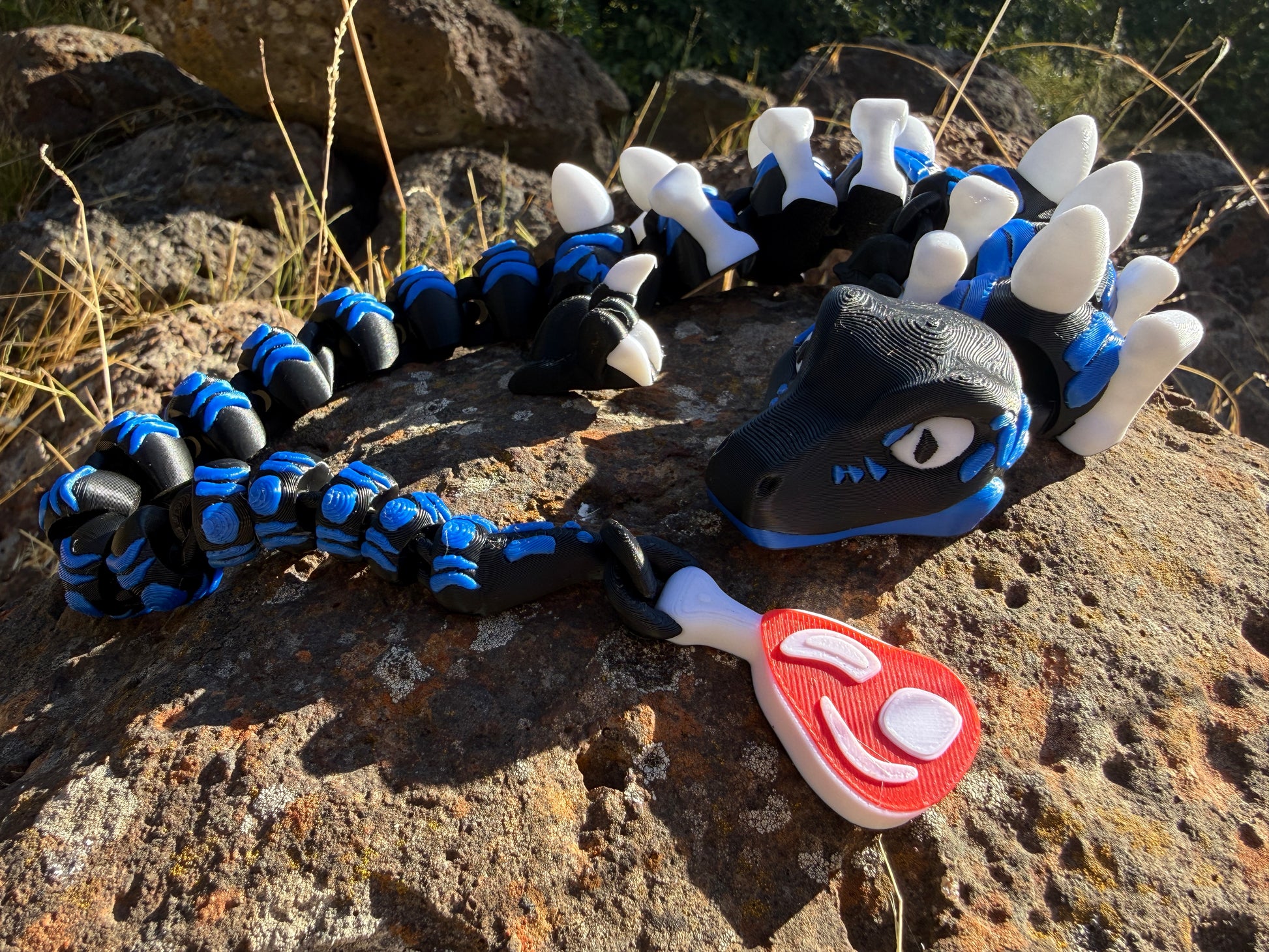 3D printed raptor black and blue. l with steak detail tail. bone and egg details down their back