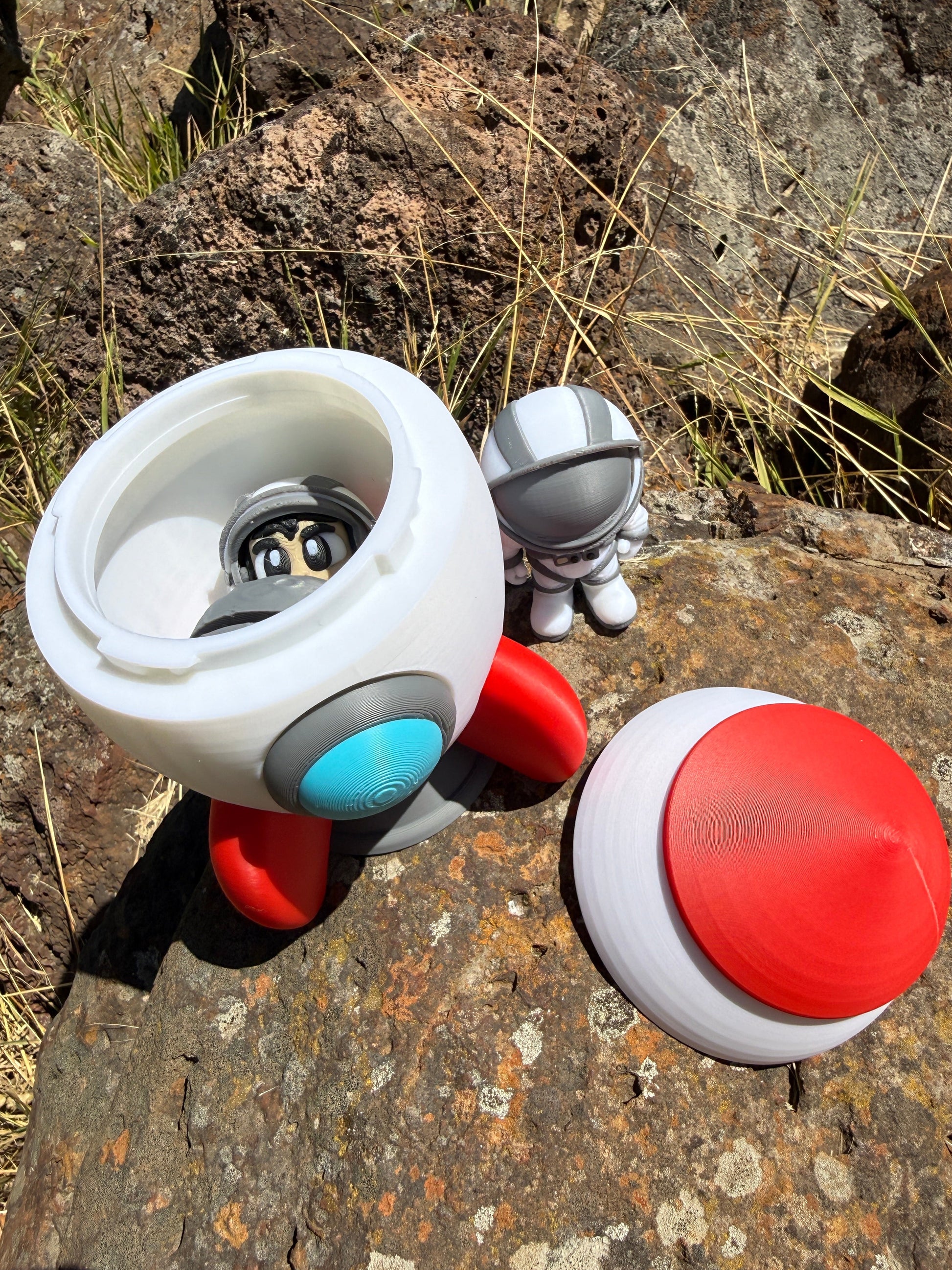 Toy rocket with red and white colors on a rocky surface