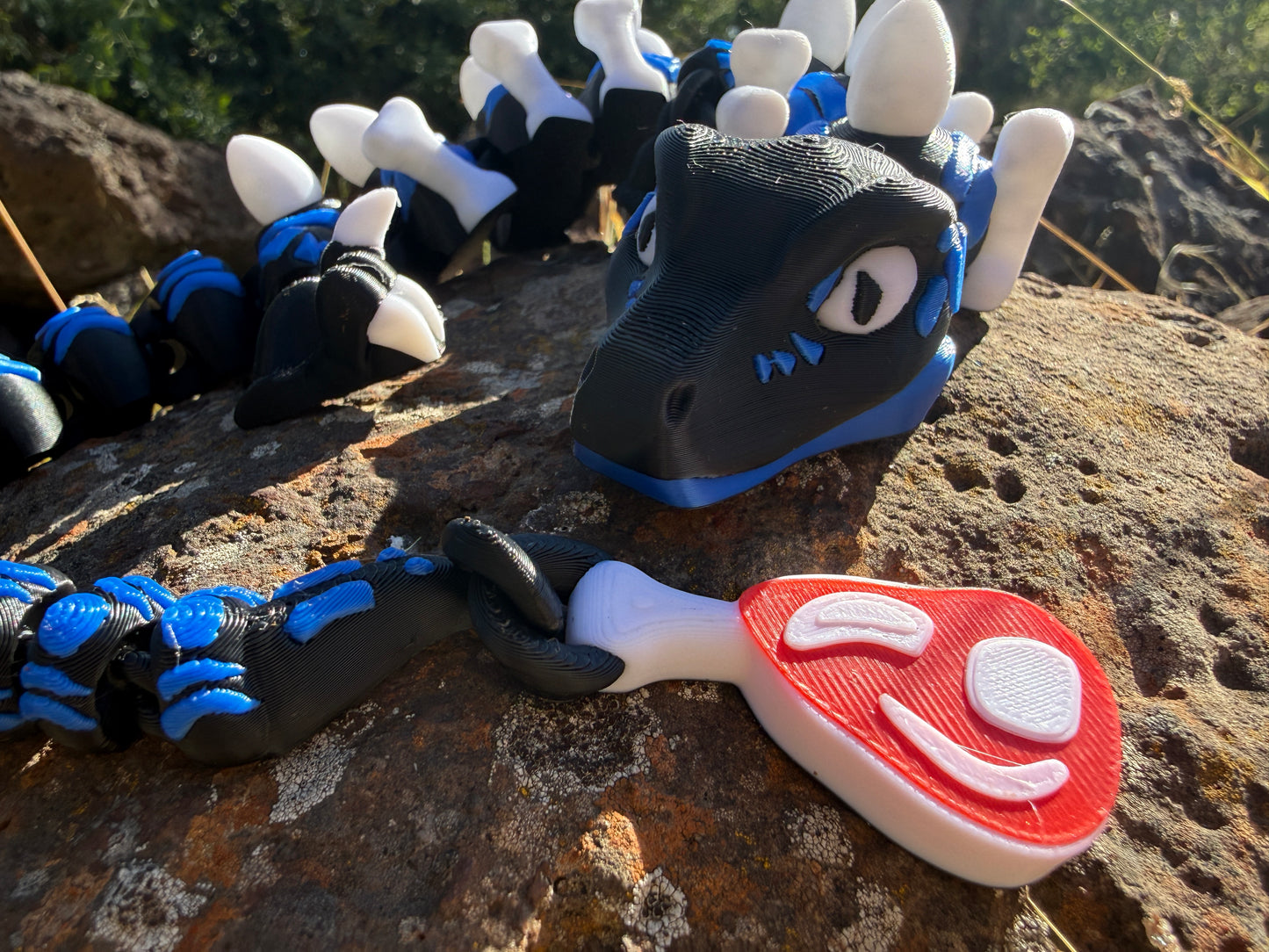 3D printed raptor black and blue. large with steak detail tail. bone and egg details down their back