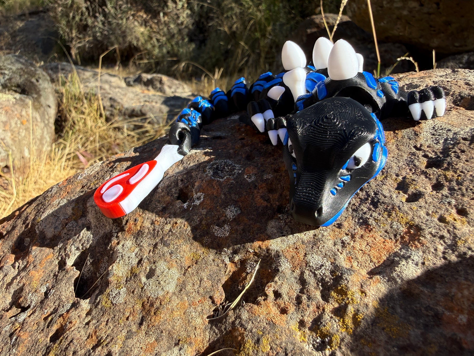 3D small printed raptor black and blue. large and small with steak detail tail. bone and egg details down their back