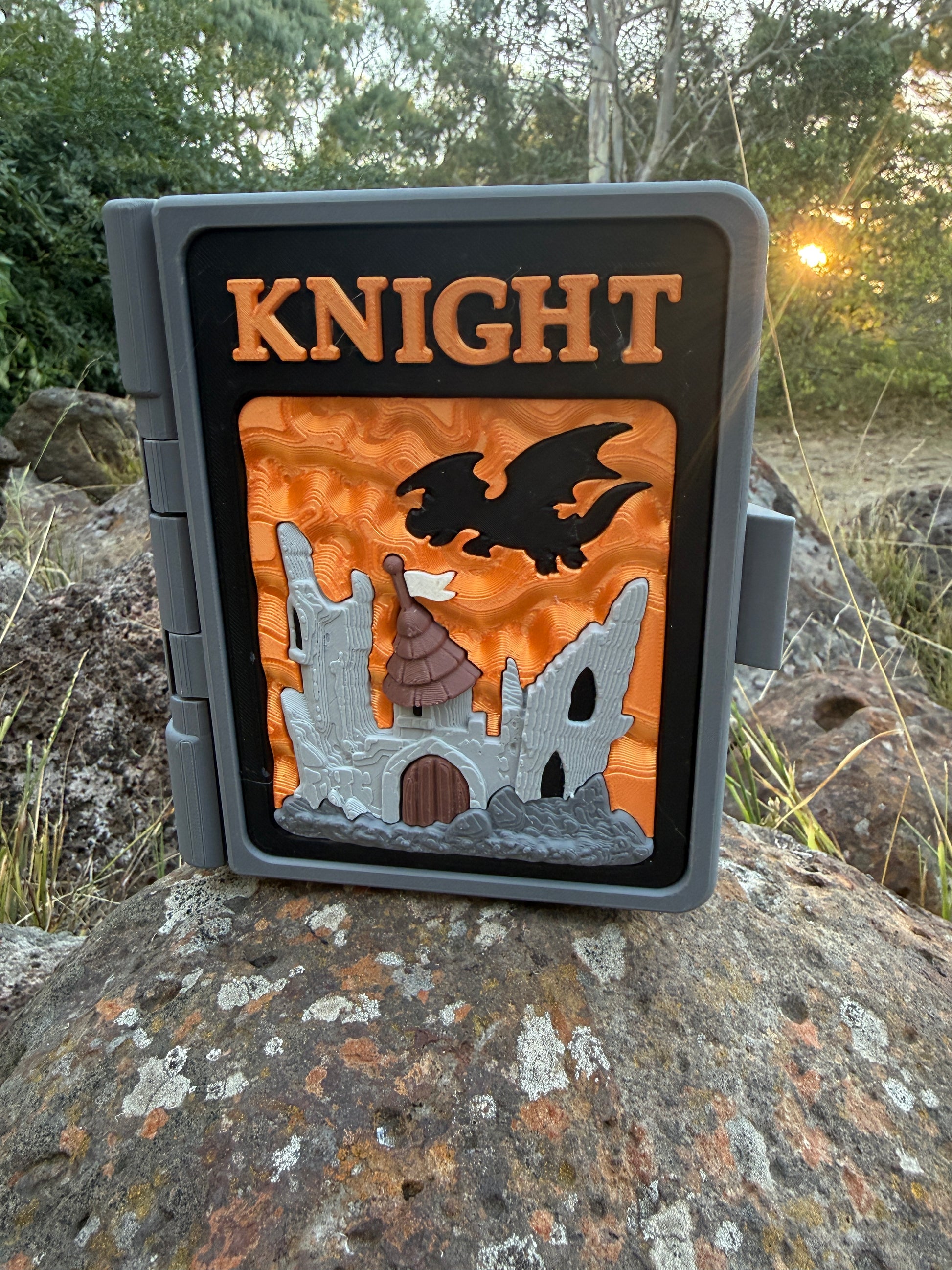 Decorative sign with 'KNIGHT' and castle design on a rock outdoors