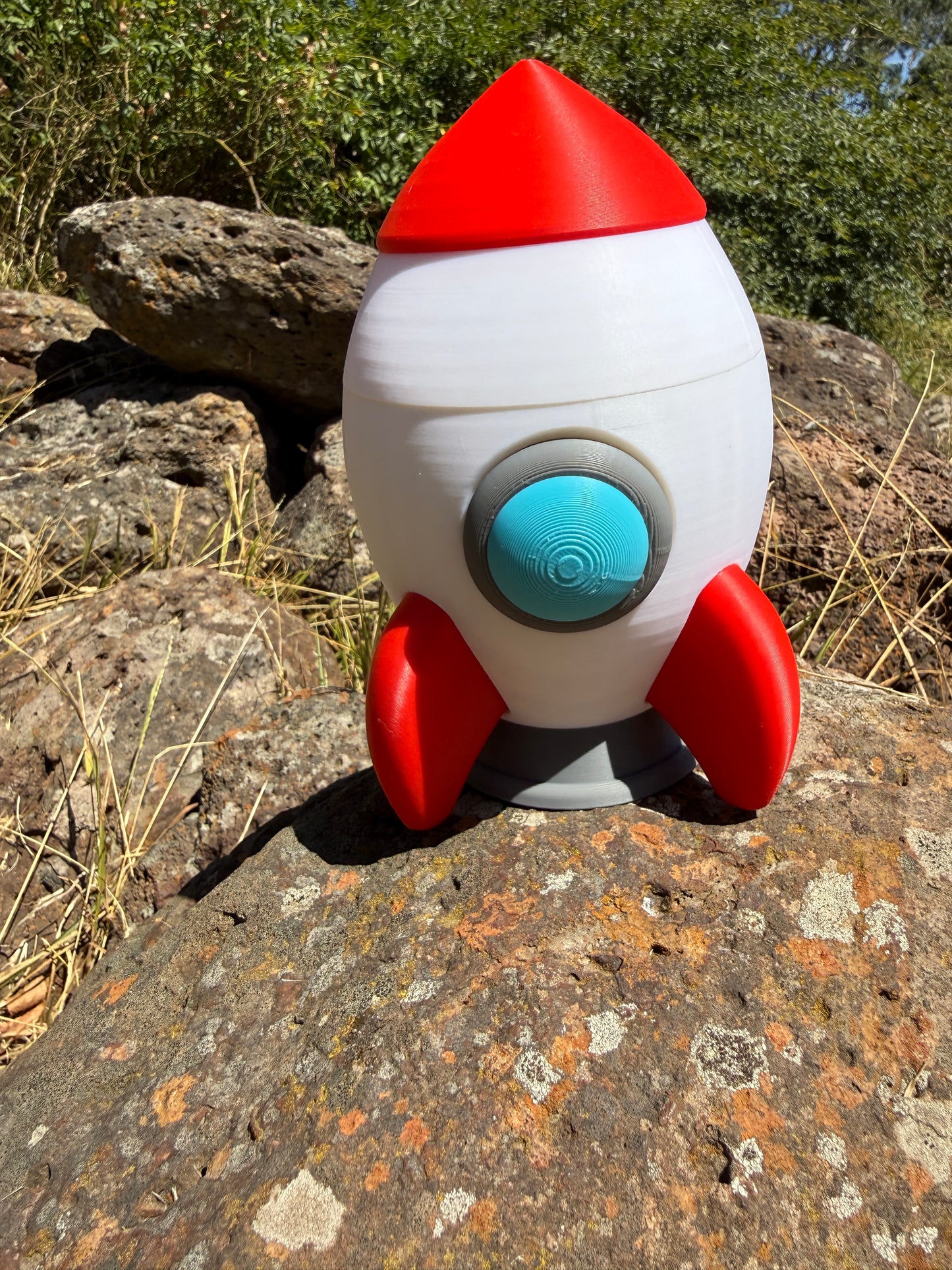 3Toy rocket with red and white design on a rocky surface printed