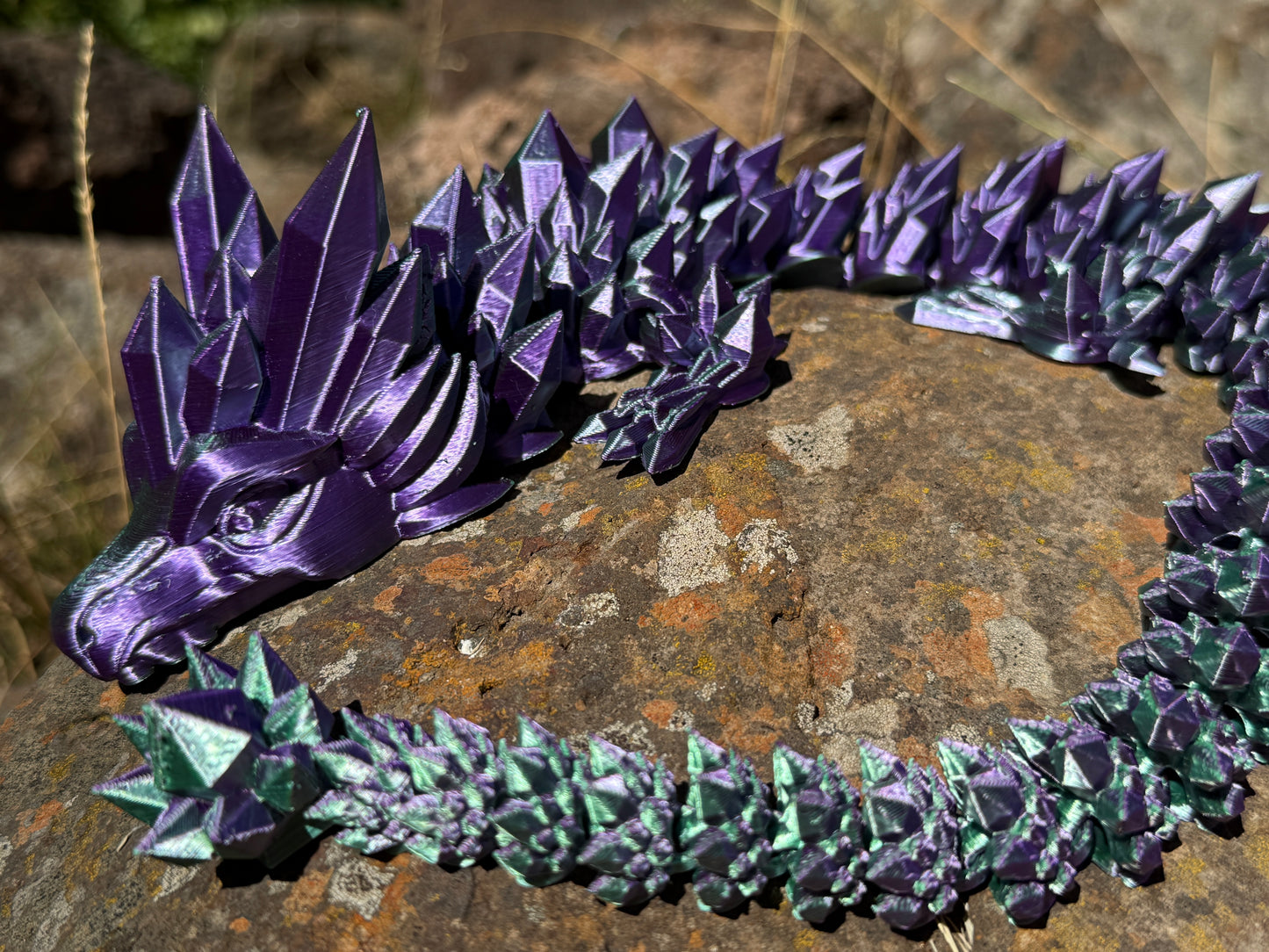 Purple and green dragon-like creature on a textured surface
