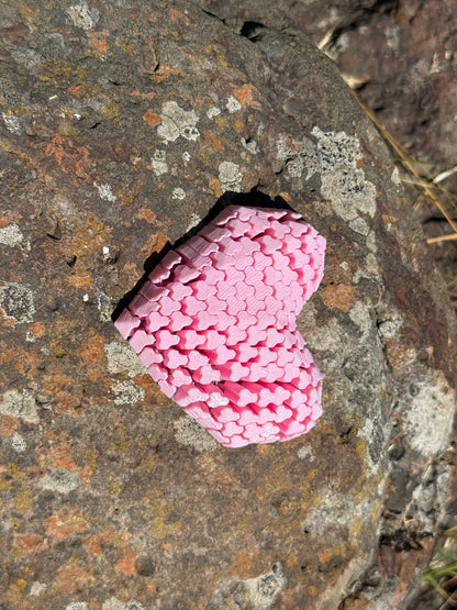 Pink heart-shaped object on a textured stone surface