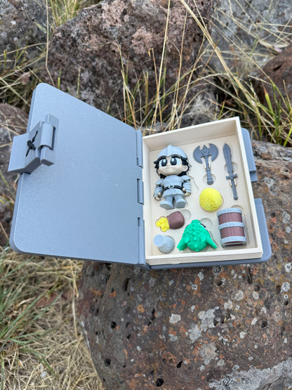 Small open 3d printed book with miniature items on a rocky surface