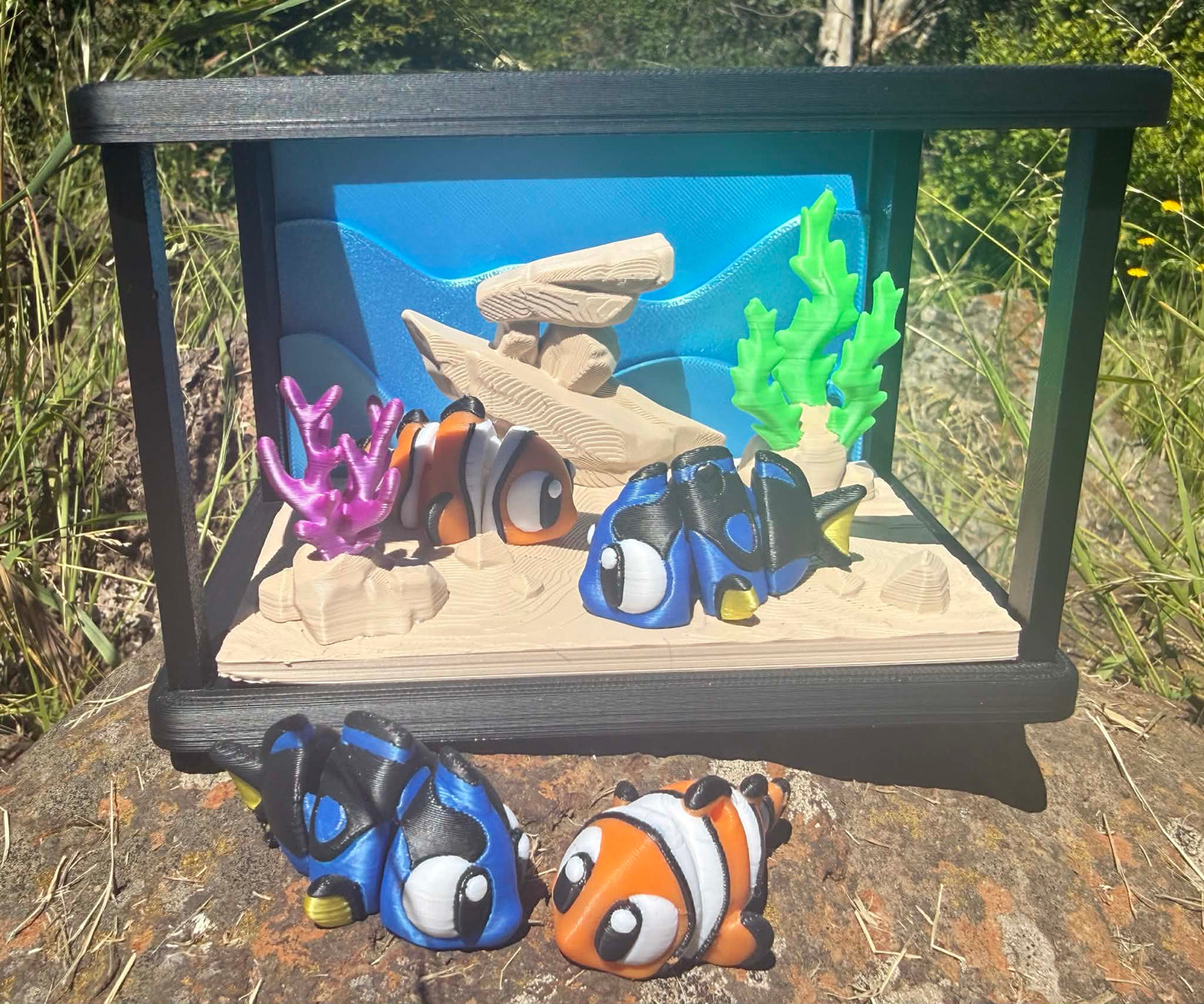 Small aquarium with decorative fish and underwater scene on a natural background