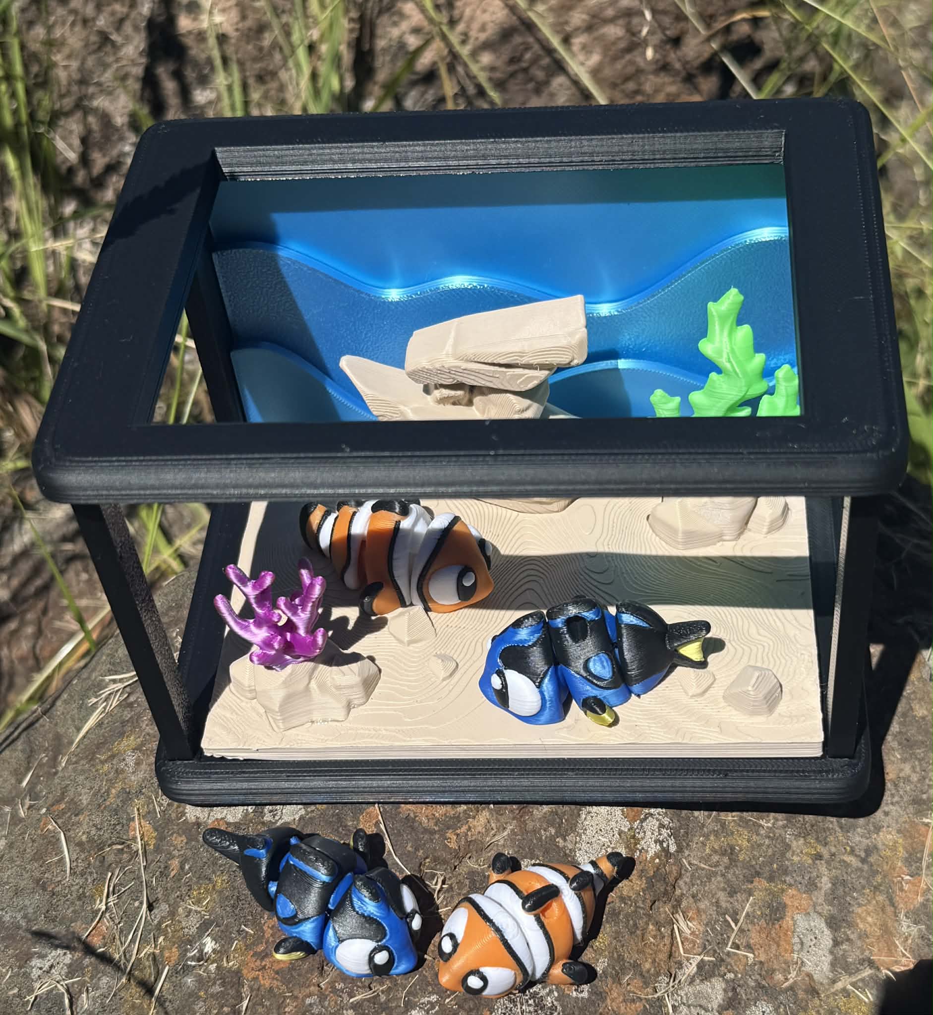Small aquarium with fish and coral on a natural background