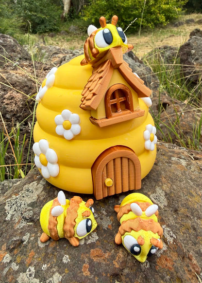 Yellow 3D printed beehive with three 3D printed bee characters on a rock