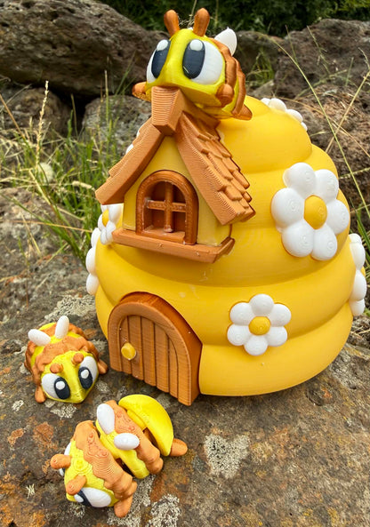 Yellow 3D printed bee-shaped house with 3D printed bee characters on a stone surface