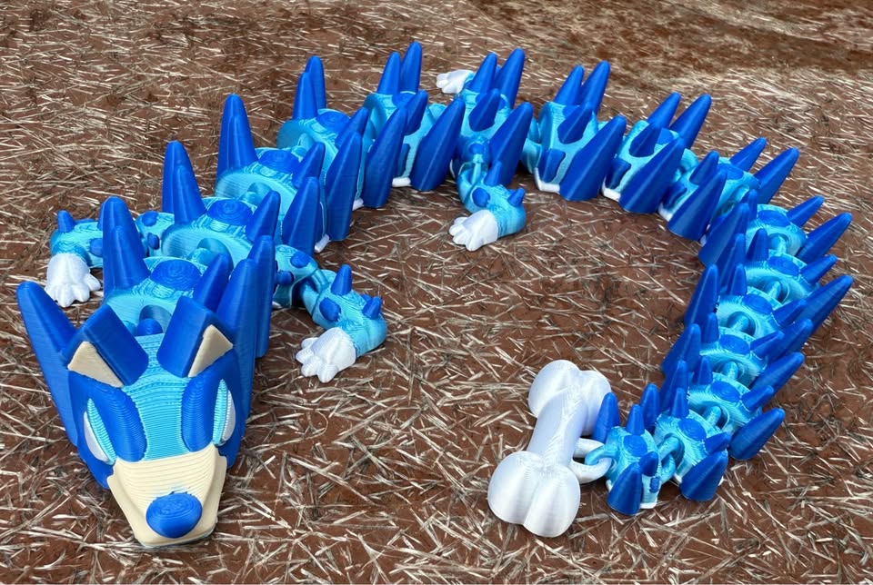 Blue 3d printed dog dragon on a brown textured surface