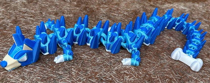 Blue and white 3d printed dog dragon on a brown surface