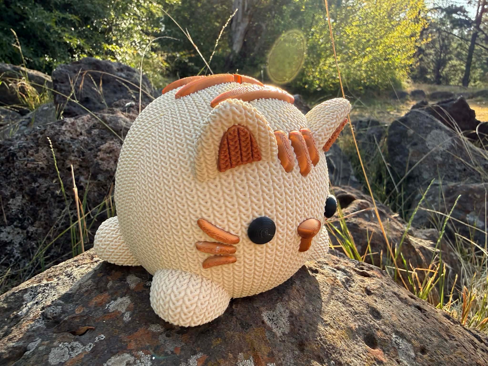 beige and copper Knitted cat money box 3d printed on a rock with a natural background