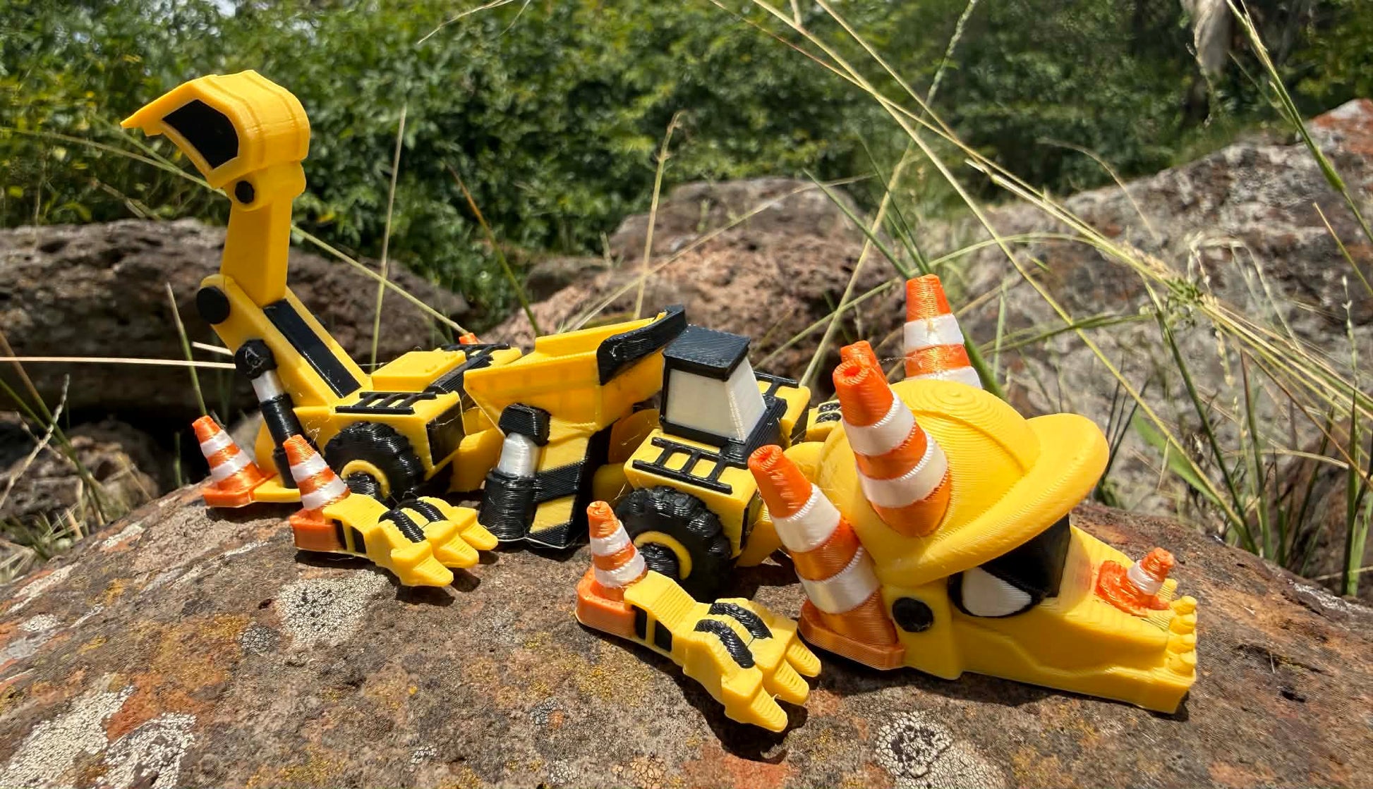 3D printed excavator mini dragon with traffic cones on a rocky surface