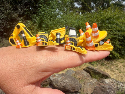 3D printed excavator mini dragon with traffic cones on a hand