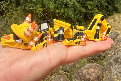 3D printed excavator mini dragon with traffic cones on a hand held flat