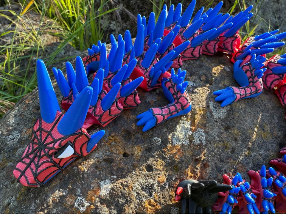 3d printed spider dragon web covered with blue and red spikes on a stone surface