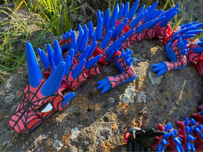 3d printed spider dragon web covered with blue and red spikes on a stone surface