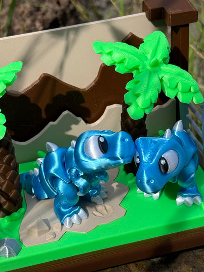 3D printed dinosaurs on a green base with a brown and beige landscape
