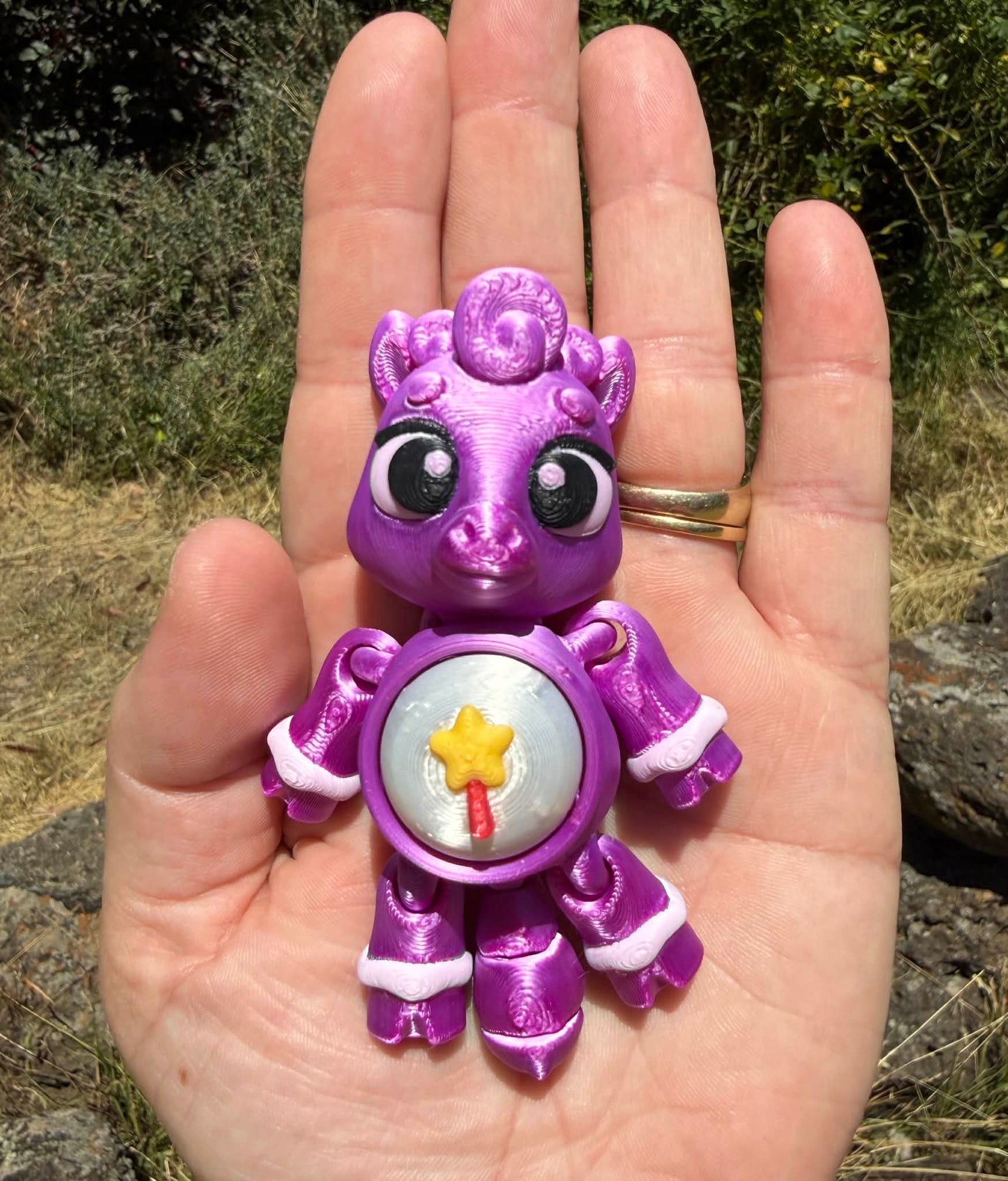 Purple 3D printed  horse  held in a hand with a natural background