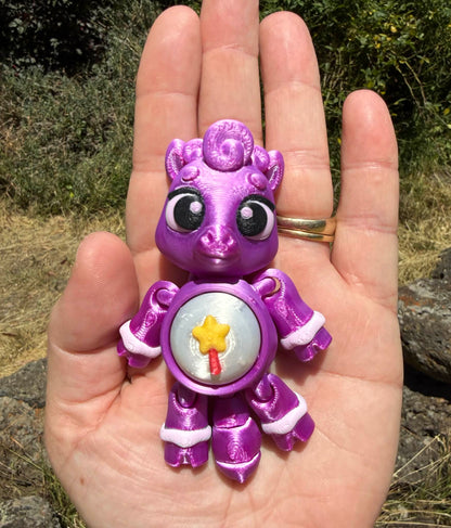 Purple 3D printed  horse  held in a hand with a natural background