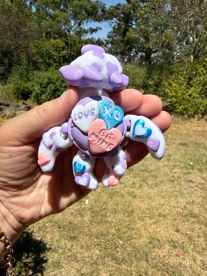 purple and blue 3d printed turtle/cow on a hand with grass in the background