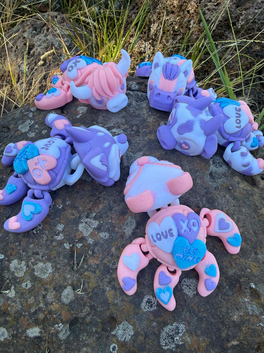 Set of colorful turtle-shaped toys on a rocky surface with grass. one panda, husky, cow, highland cow and horse
